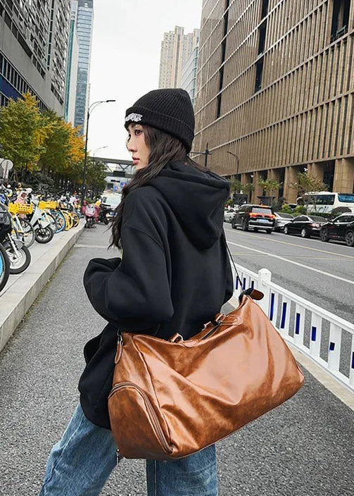 Person holding a brown bag on a city street with text 'NEVER FADE' and 'ALWAYS KEEP UP'.