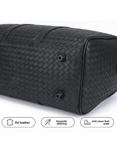 Black woven duffel bag with premium craftsmanship details on a white background