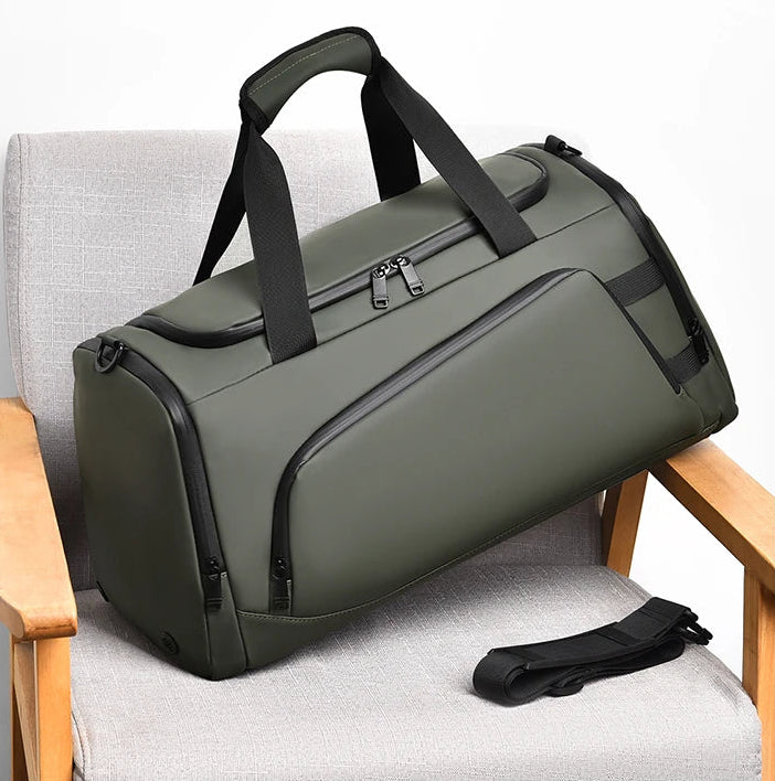 Green duffel bag with black straps on a chair with a neutral background