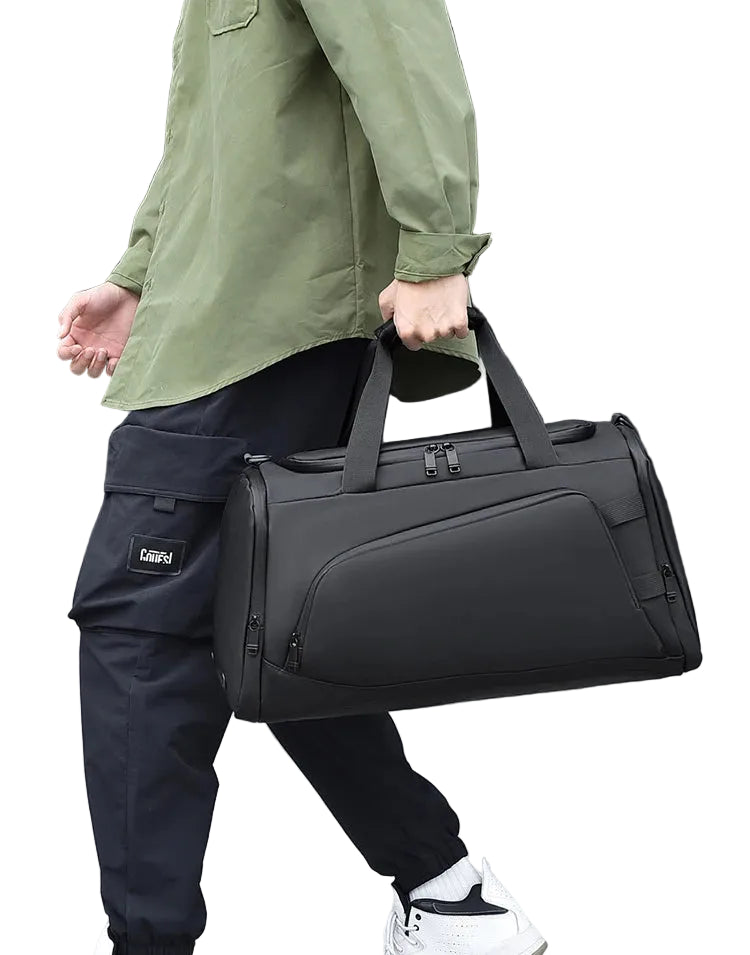 Person holding a black duffel bag with a blurred background