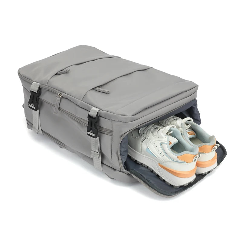 Gray travel duffel bag with white sneakers inside on a white background