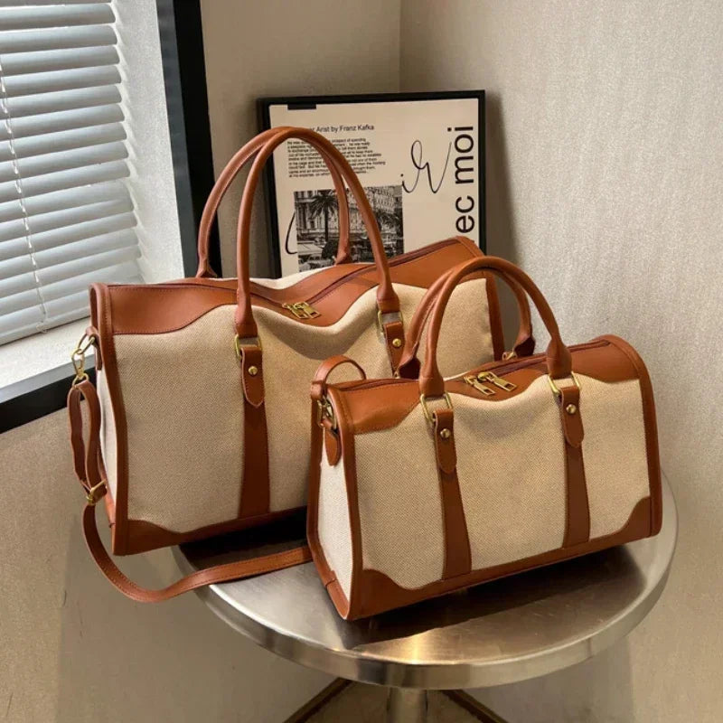 Two beige handbags with brown accents on a round metal table.