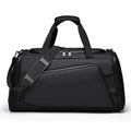 Black duffel bag with shoulder strap on a white background