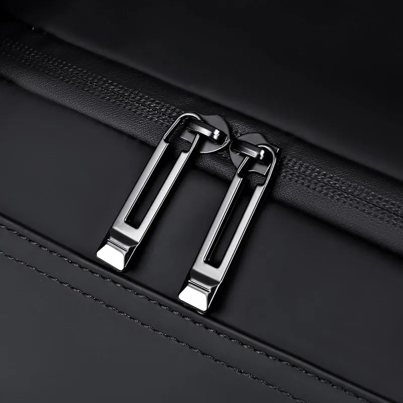 Close-up of a black leather bag with a metal zipper pull.