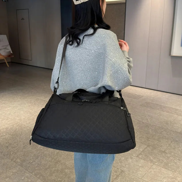 Person wearing a black shoulder bag in an indoor setting