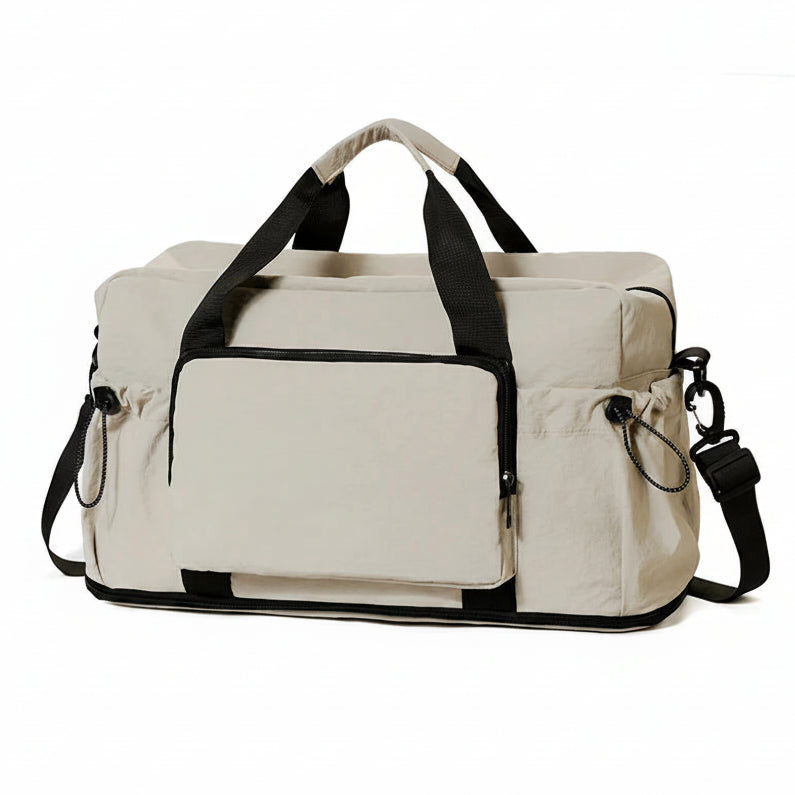 Beige duffel bag with black straps on a white background