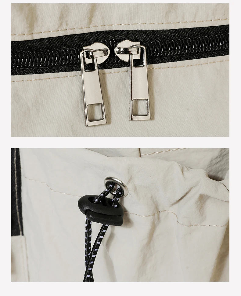 Close-up of a zipper on a beige bag with a black pull tab.