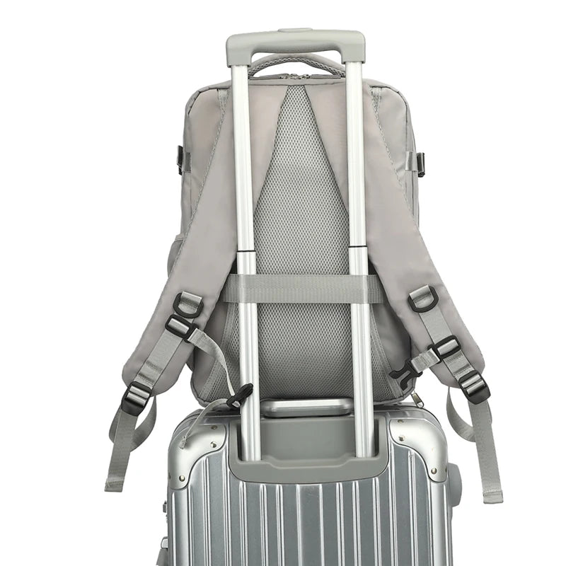 Gray backpack with straps attached to a silver suitcase on a white background