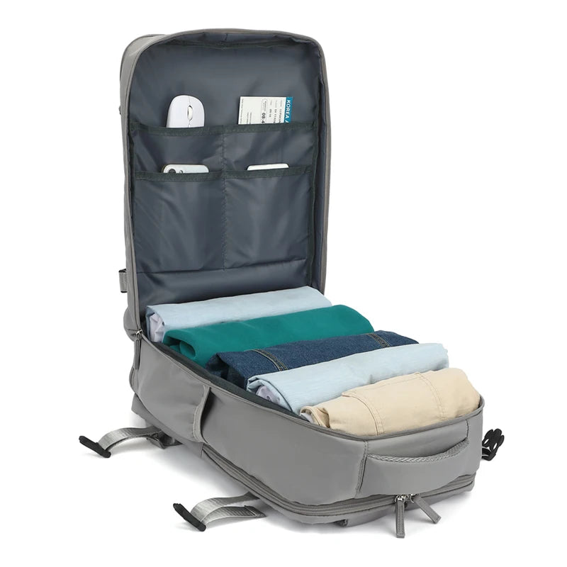 Gray backpack with clothes neatly folded and organized inside on a white background