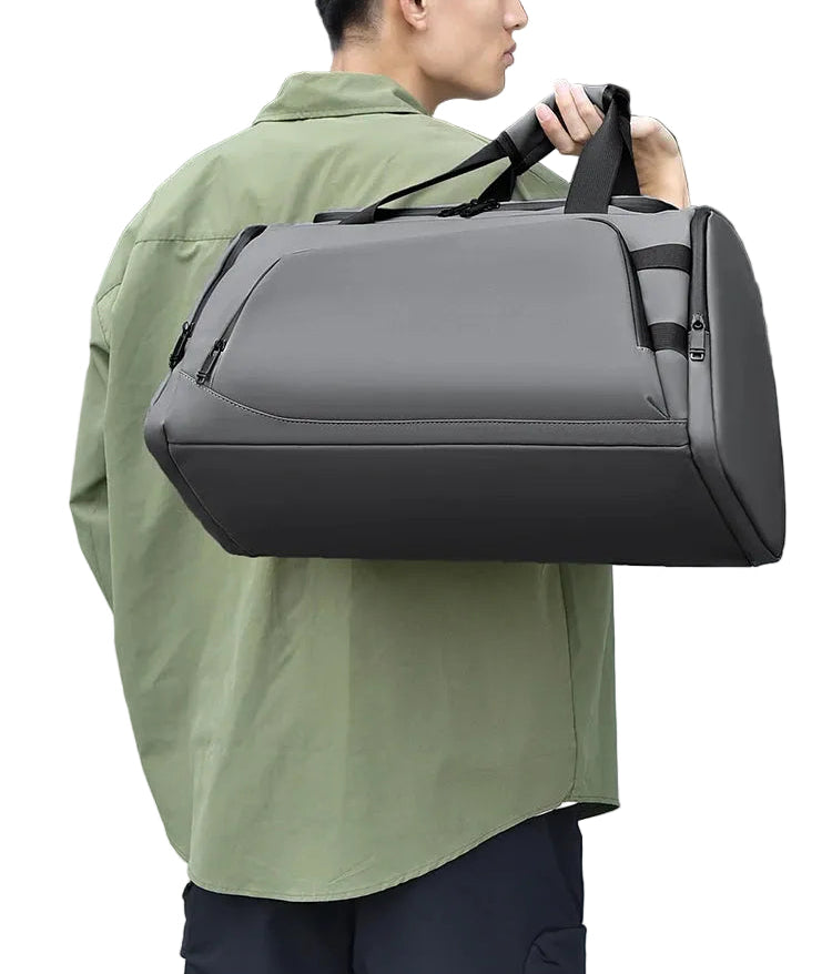Person holding a gray duffel bag outdoors